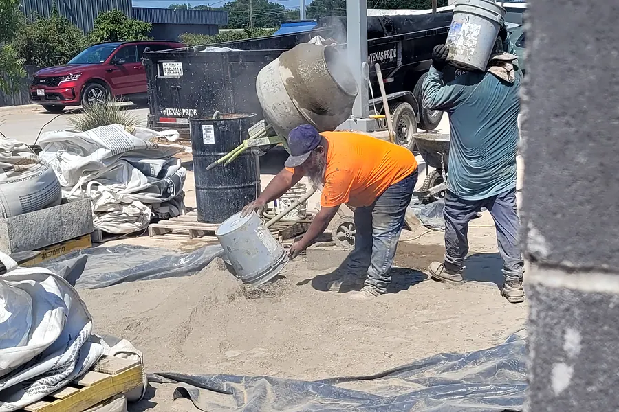 Concrete crew placing and finishing concrete on a sunny North Texas job site