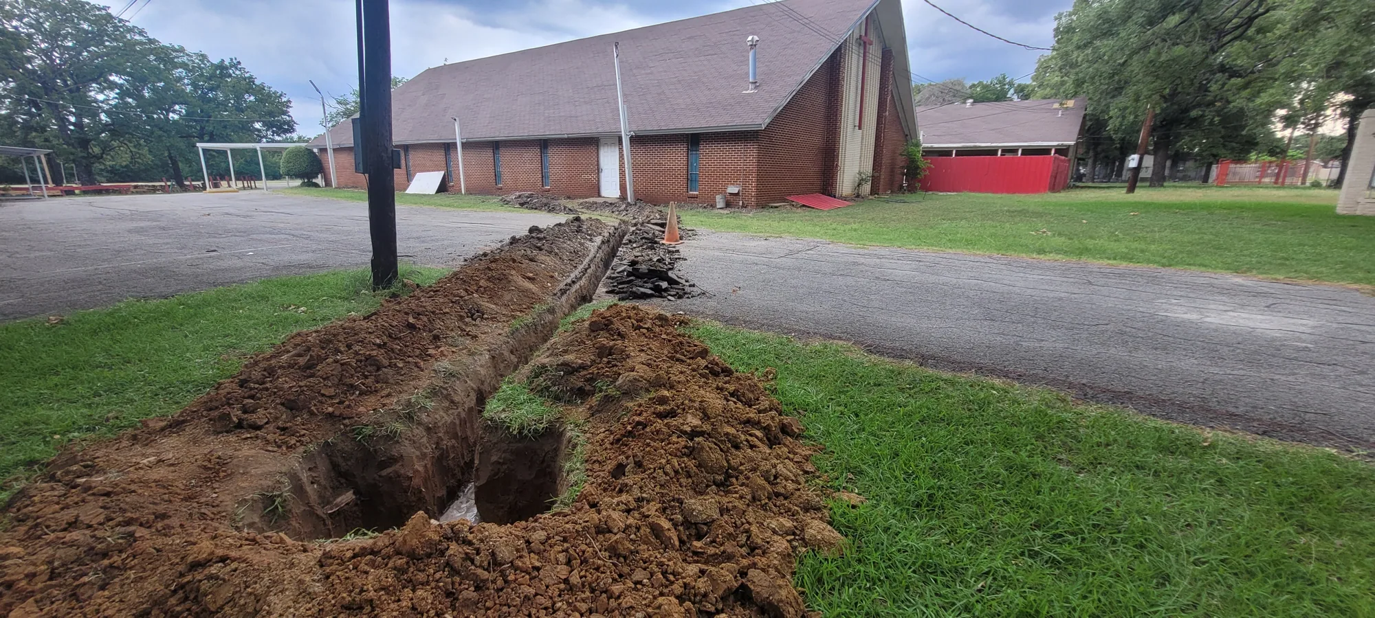 Drainage trench dug across a North Texas lawn for a French drain installation