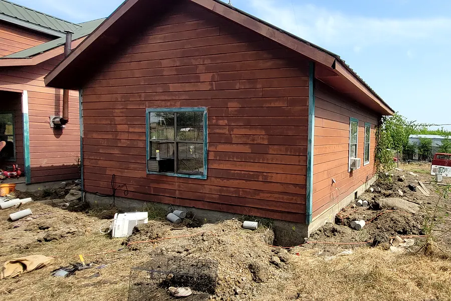 Painted wood siding and trim on the exterior of a North Texas home during repair work