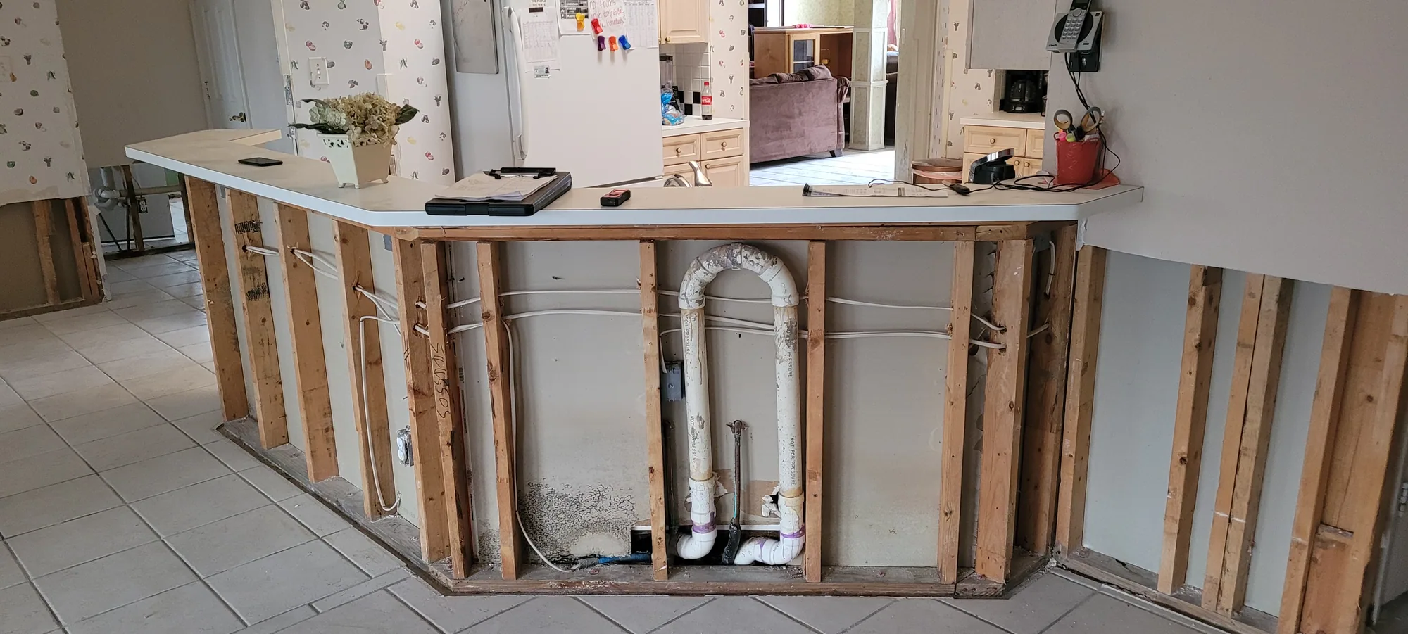 Wall opened to expose water supply lines during water damage mitigation in a DFW home