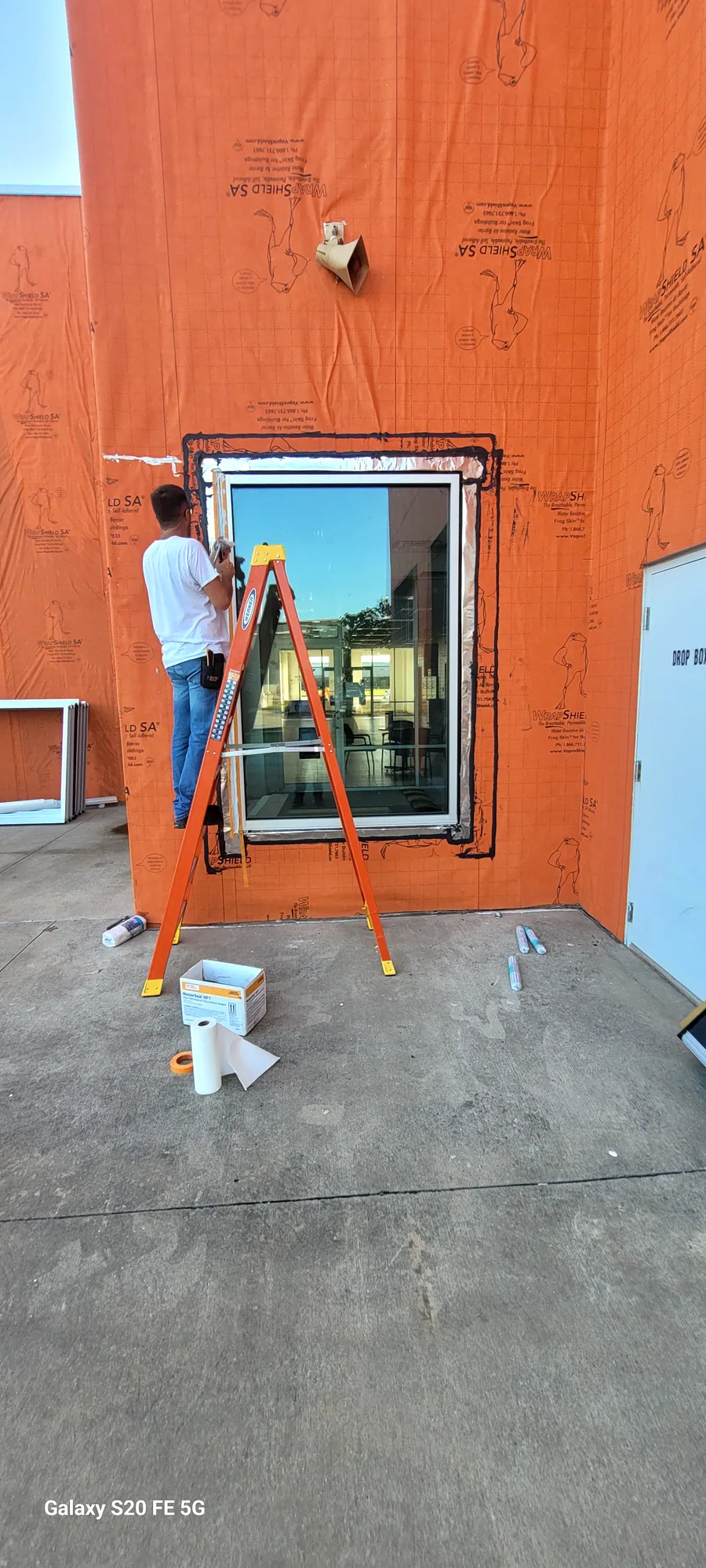 Installer setting a replacement window in an opening on a North Texas building